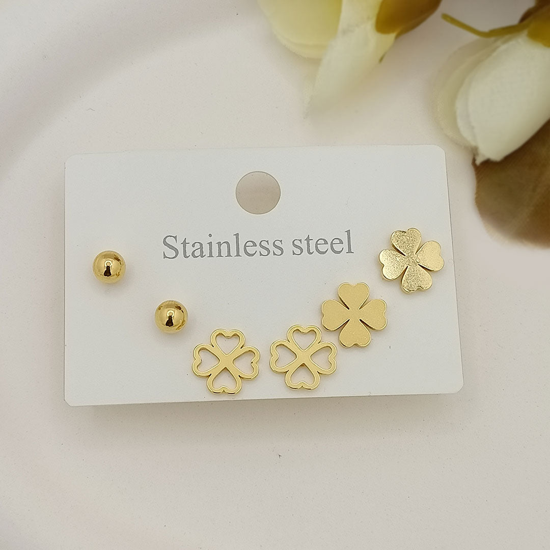 Clover / four-leaf floral motif, paired with classic gold ball studs